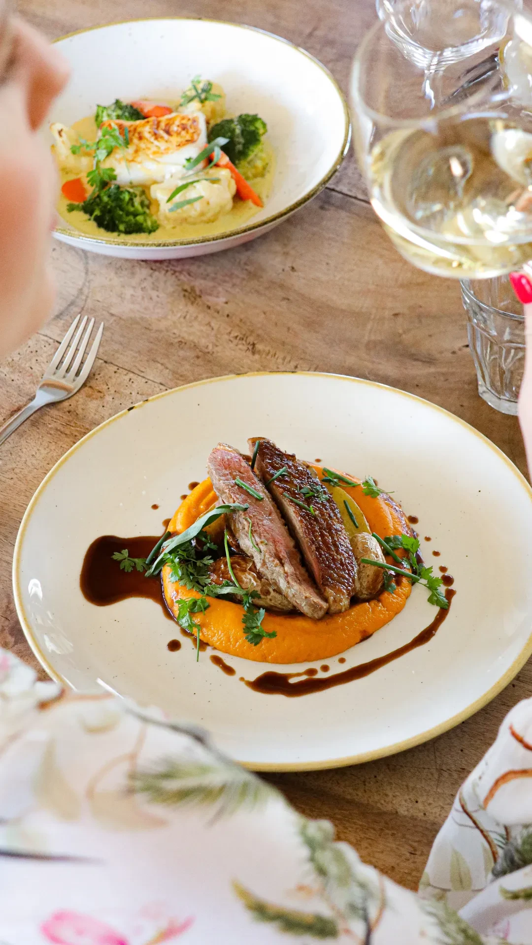 Assiette gastronomique avec viande et purée orange.