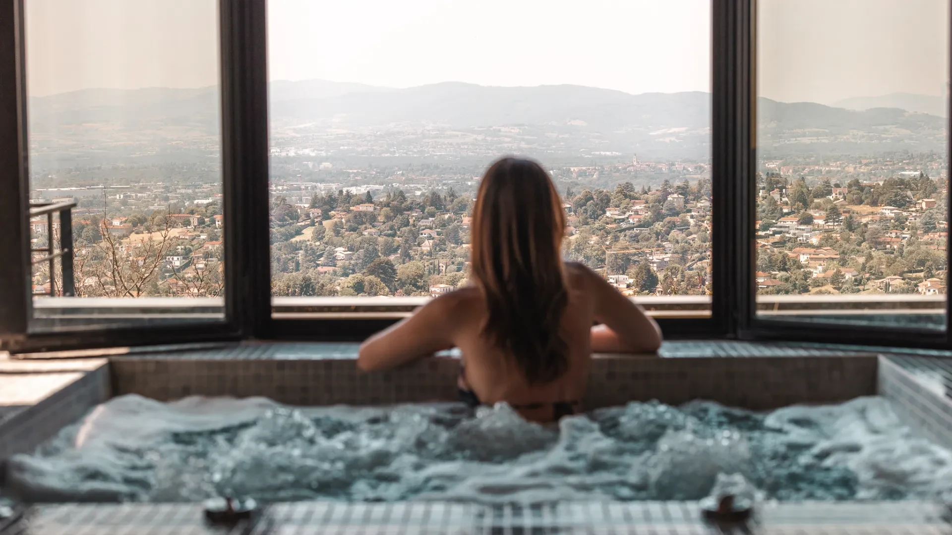 Femme dans un jacuzzi avec vue panoramique.