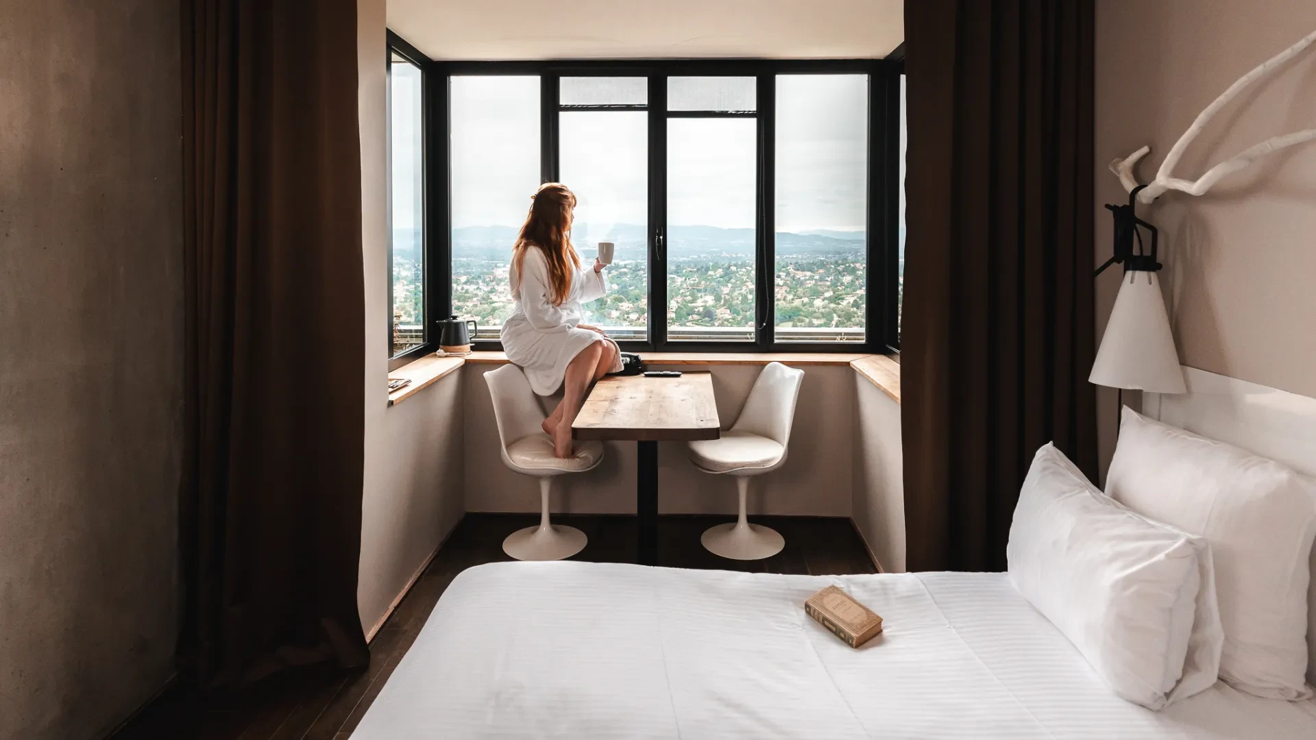 Femme buvant café près de fenêtre avec vue.