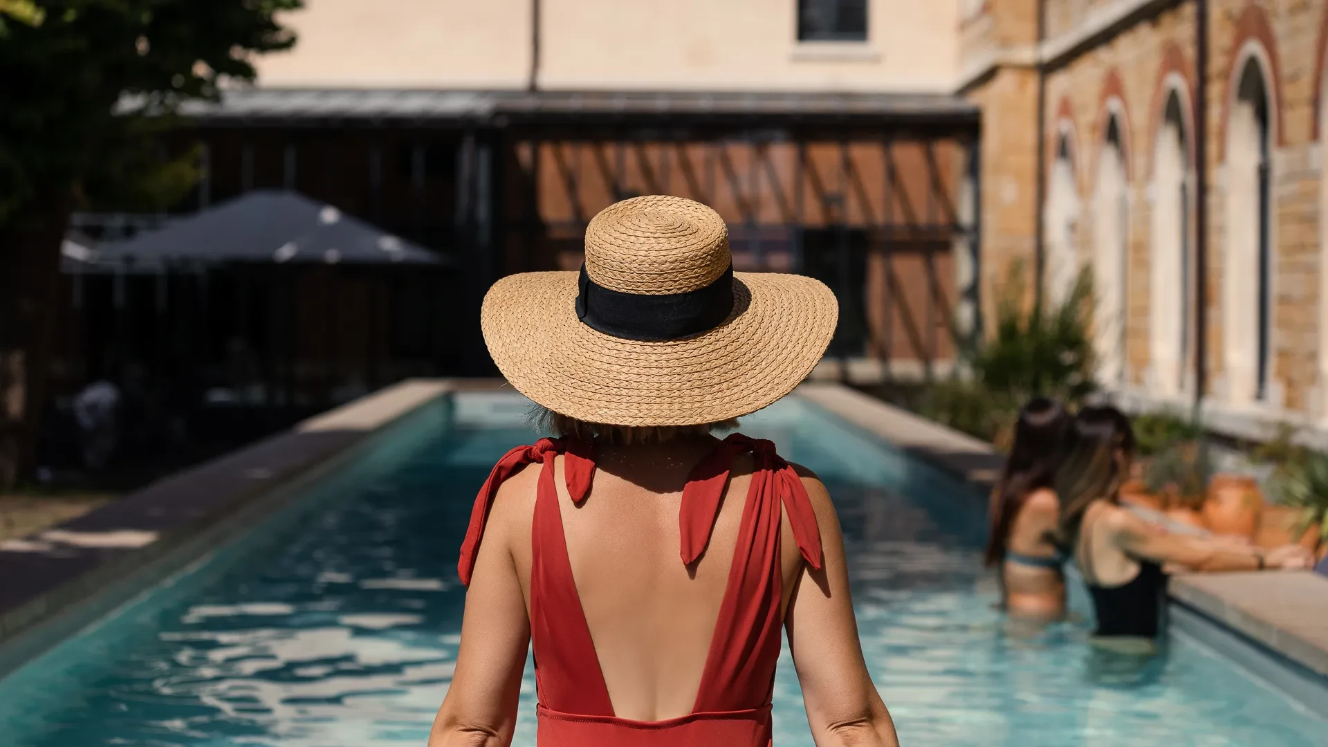 Personne en chapeau devant la piscine.