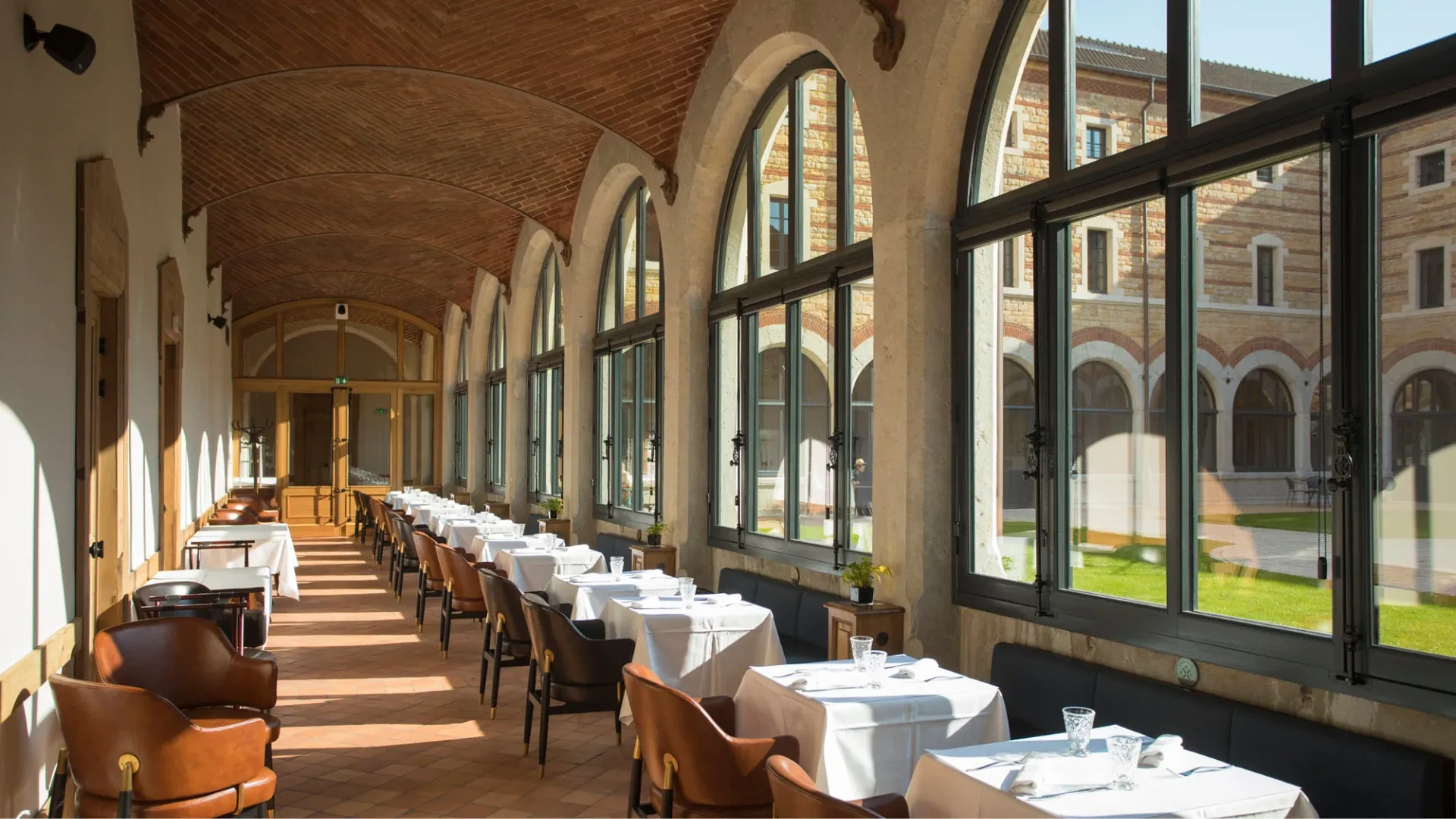 Salle à manger lumineuse avec grandes fenêtres.